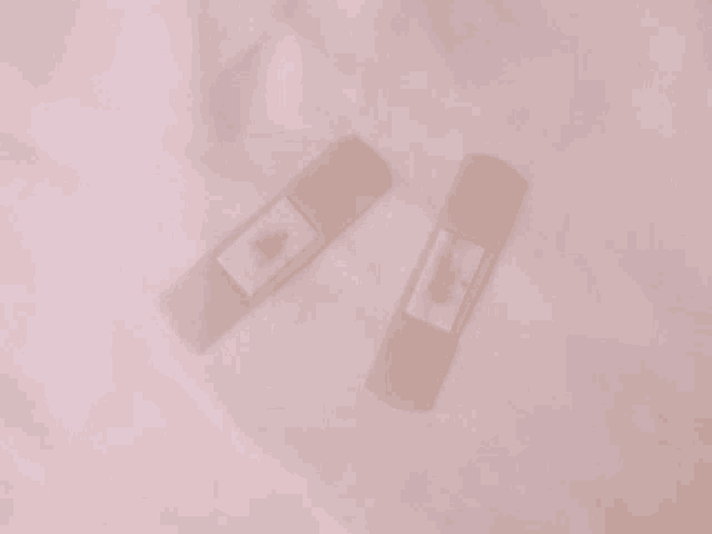 two bandages are laying on a white cloth on a bed .