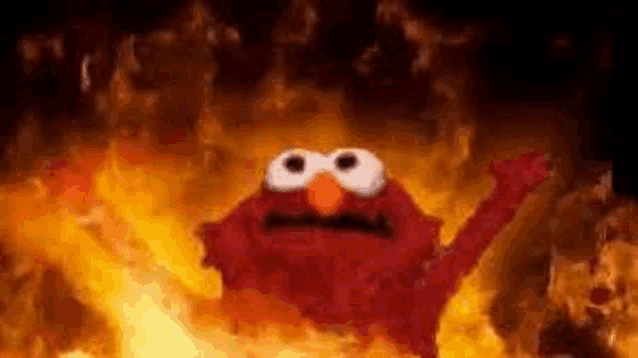 elmo from sesame street is flying through the air in a fire .