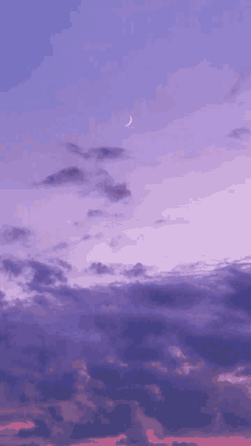 a purple sky with clouds and a crescent moon in the middle