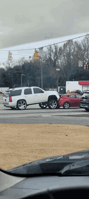 a white suv and a red car are stuck in traffic