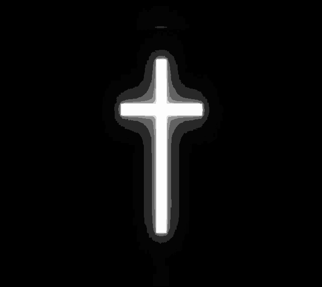 a white cross is glowing in the dark against a black background .