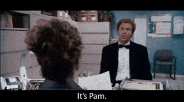 a man in a tuxedo is talking to a woman in a cubicle and the woman is saying it 's pam