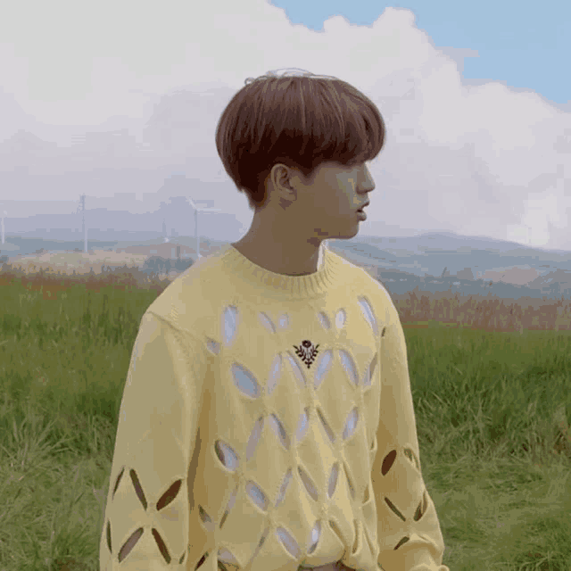 a boy wearing a yellow sweater with holes in it