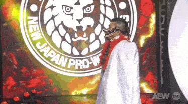 a man is standing in front of a logo that says new japan pro-w