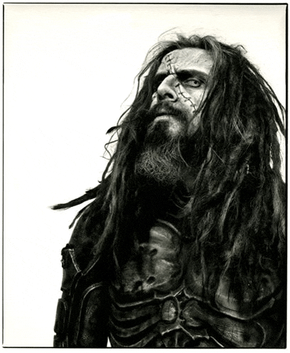 a man with dreadlocks and a beard looks up at the sky