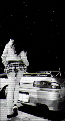 a woman in a plaid skirt is standing next to a white car with a license plate that says ' nc '