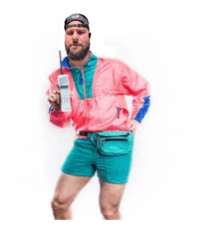 a man with a beard is wearing shorts and a pink jacket while holding a cell phone .