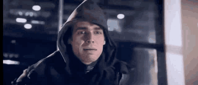 a man wearing a hoodie is looking at the camera .