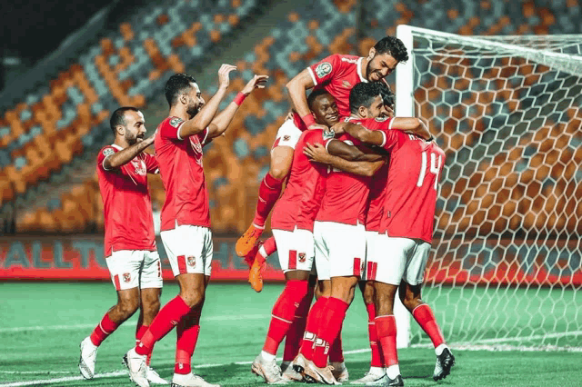 a group of soccer players are hugging each other and one of them has the number 10 on his jersey