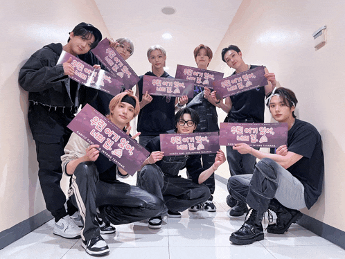 a group of young men are posing for a picture while holding up signs that say ' we are a team ' on them