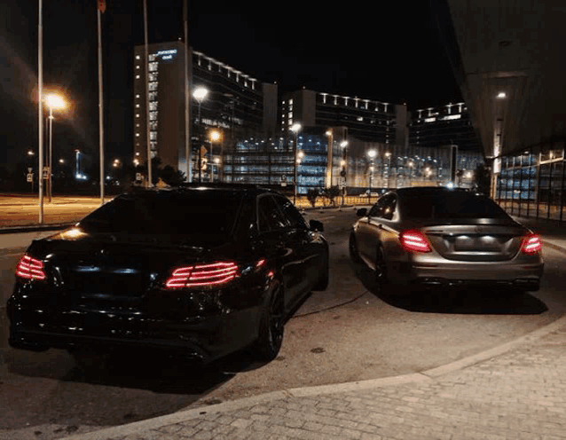 two black cars are parked next to each other in front of a building that says ' residence inn ' on it