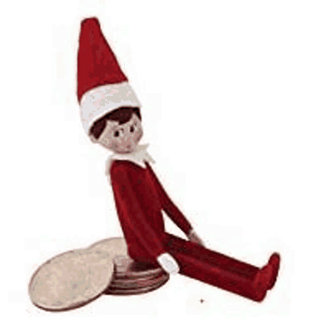 a stuffed elf is sitting on a pile of coins .