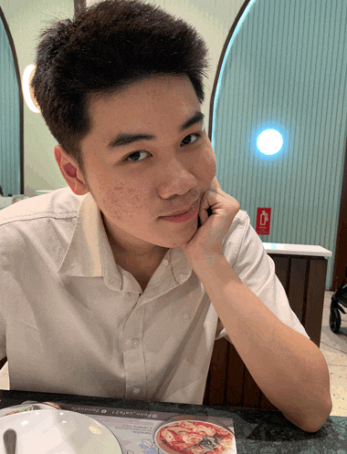 a young man sits at a table with a plate of pizza on it and a menu that says spinach