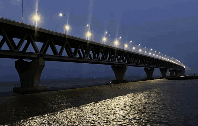 a bridge over a body of water at night with lights on