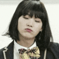 a girl in a school uniform and bow tie is making a face .