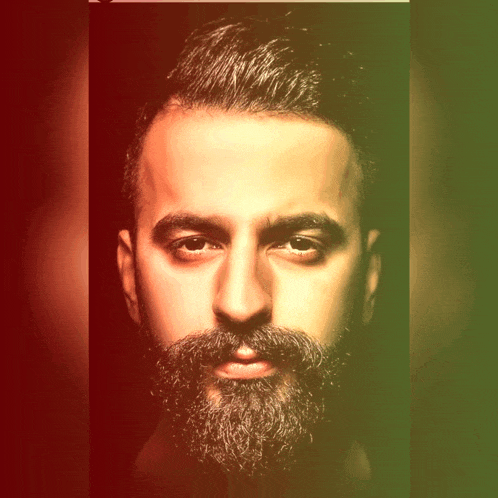 a man with a beard looks at the camera with a red and green background