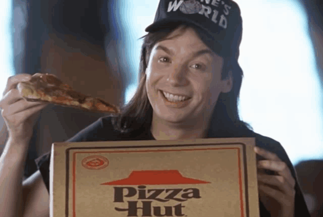 a man wearing a world hat is holding a box of pizza hut