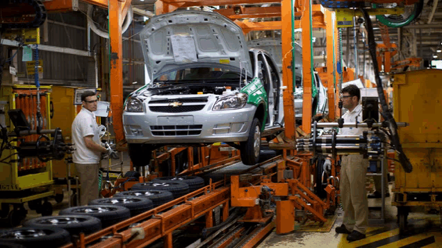 a car is being assembled in a factory with the hood open