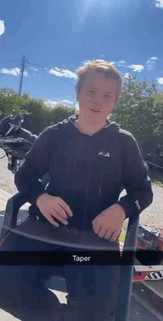 a young boy is sitting in a chair in front of a motorcycle and a motorcycle .