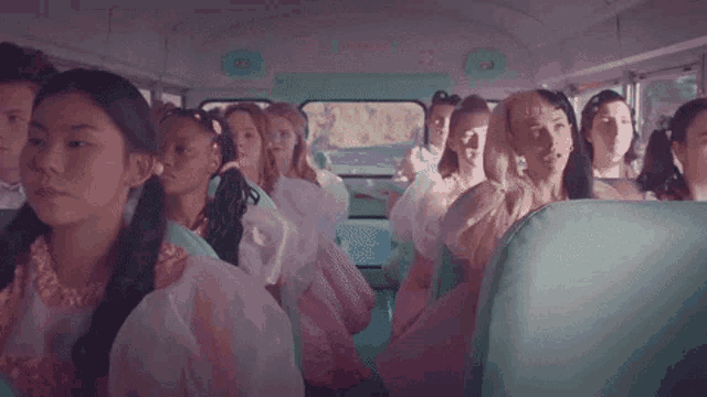 a group of young girls are sitting on a bus .