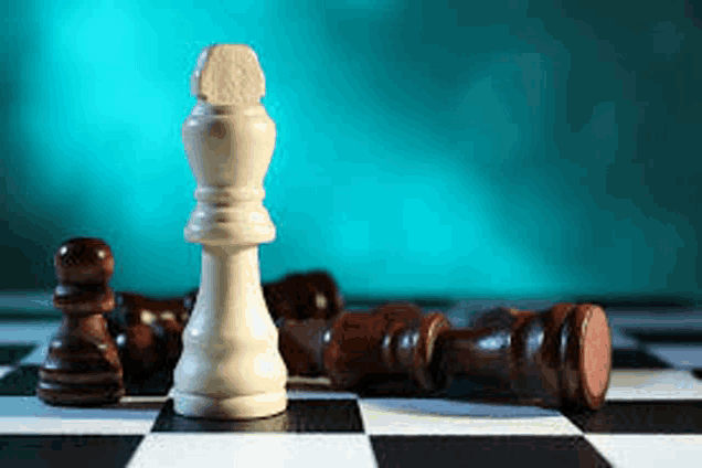 a white chess piece is standing in the middle of a chess board surrounded by brown chess pieces .