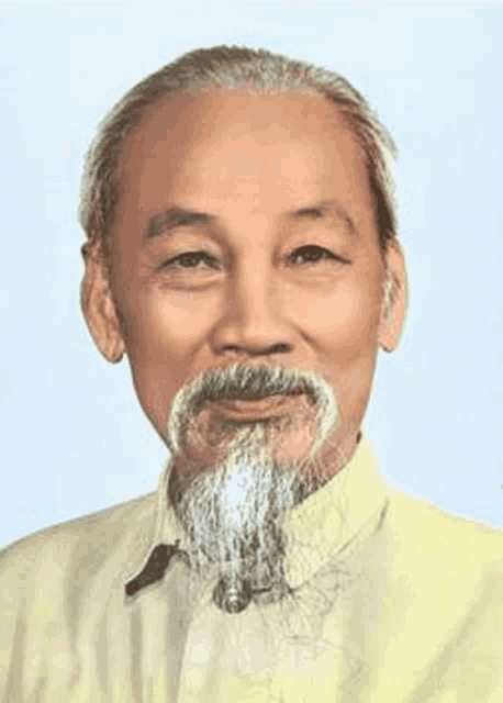 a man with a beard wearing a yellow shirt is smiling