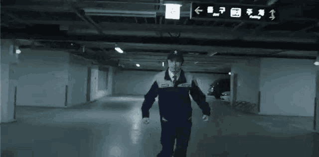 a security guard is walking through a parking garage .