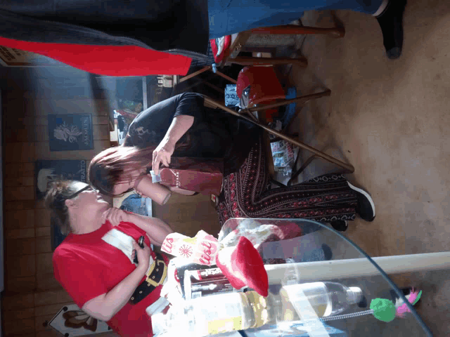 a woman in a red shirt that says coca cola on it is sitting next to another woman