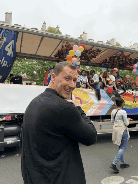 a man stands in front of a truck with the letter a on the side