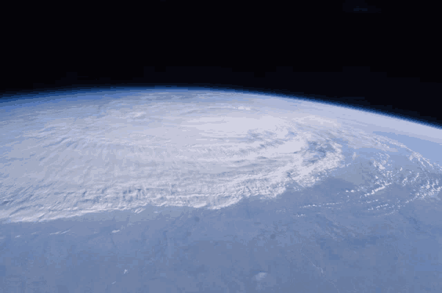 a view of the earth from space shows a hurricane on the horizon