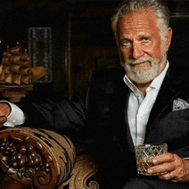 a man in a suit holds a glass of whiskey