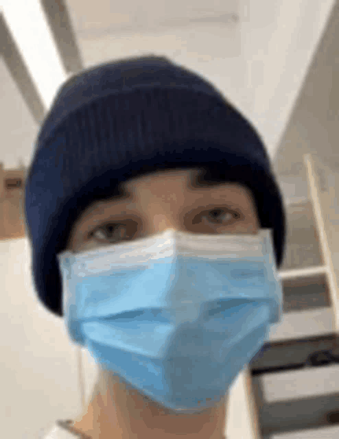 a man wearing a blue beanie and a blue mask .