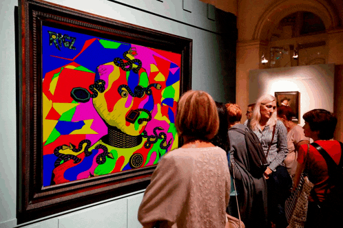 a woman looks at a colorful painting with the letters rklz on it