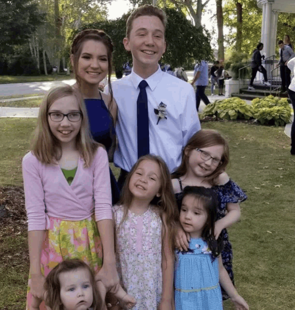 a group of children posing for a picture with a man wearing a tie