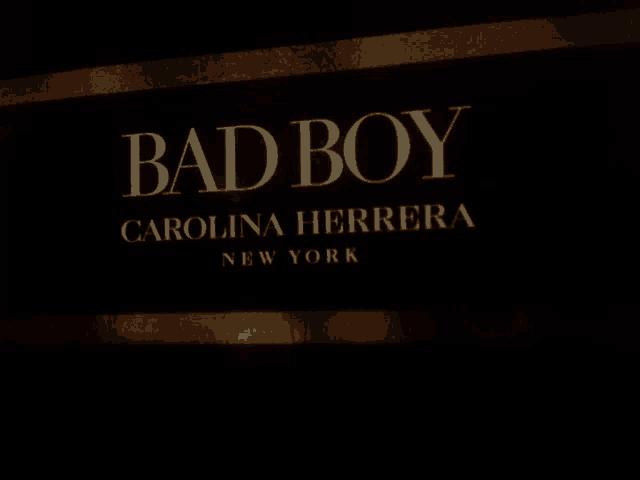 a black sign that says bad boy carolina herrera new york on it