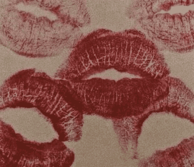 a close up of a woman 's lips with red lipstick on them on a beige background .