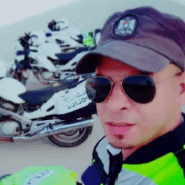 a man wearing sunglasses and a hat stands in front of a motorcycle that says police on it