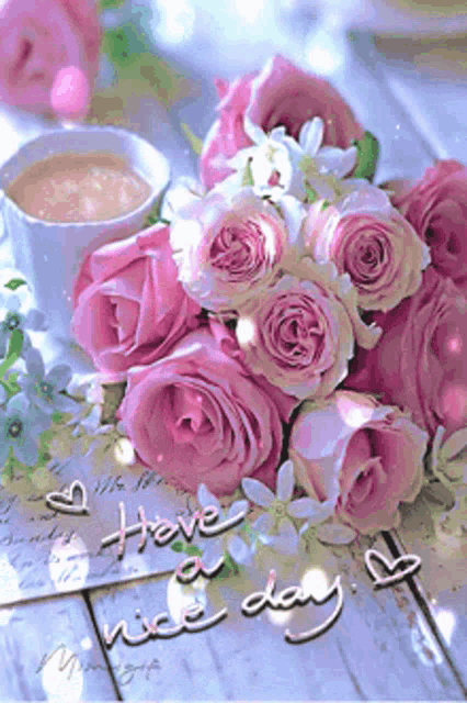 a bouquet of pink roses sits next to a cup of coffee