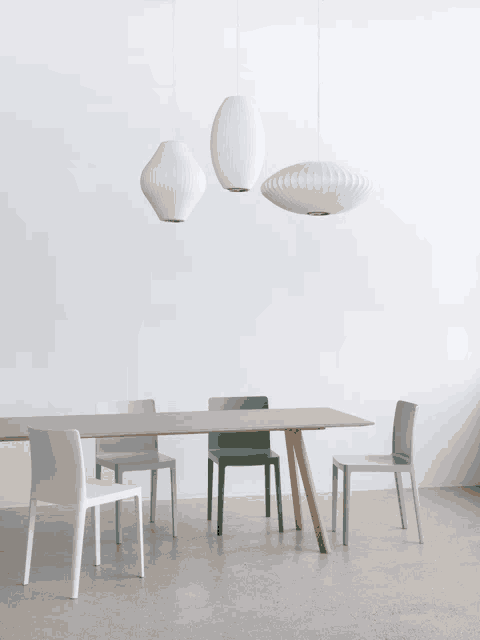 a dining room with a table and chairs and pendant lights