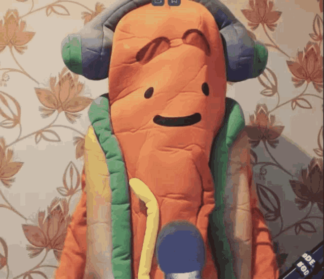 a stuffed hot dog wearing headphones and a remote control