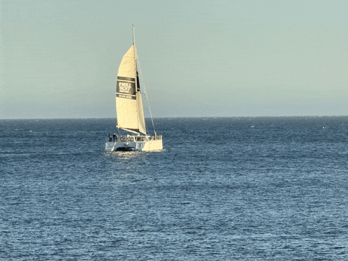 a sailboat in the ocean has a banner on the sail that says " circle island "