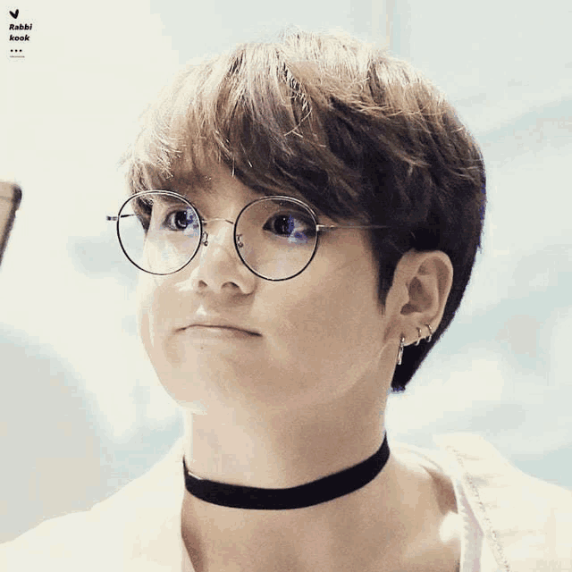 a close up of a person wearing glasses and a choker that says rabbi and kook