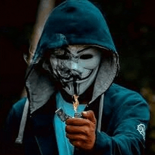 a man wearing a hooded jacket and a mask is holding a lighter .