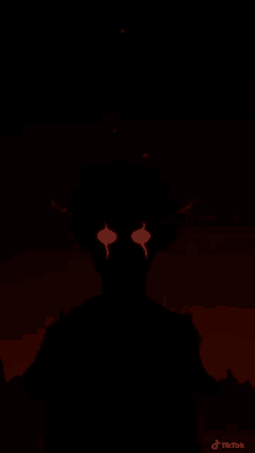 a silhouette of a monster with red eyes is standing in the dark .