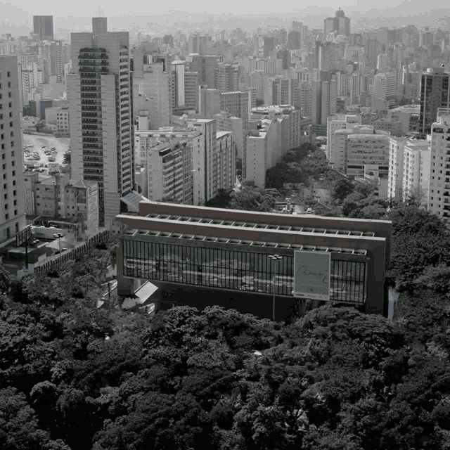 a black and white photo of a city with a large building in the foreground that says ' allianz ' on the side