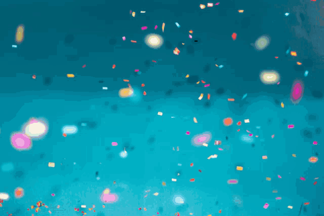 a blue background with a lot of confetti falling from the sky