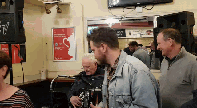 a man is playing an accordion in front of a sign that says ' irish cup festival ' on it