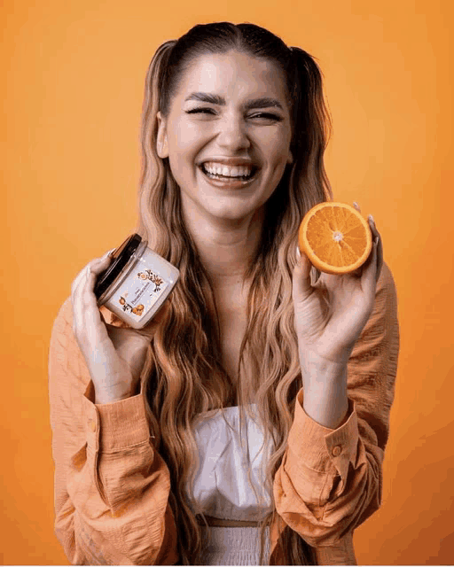 a woman holding an orange and a jar that says ' sally ' on it