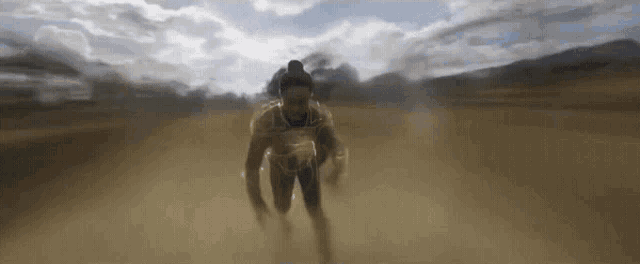 a man is running through a dirt field in a blurred image .