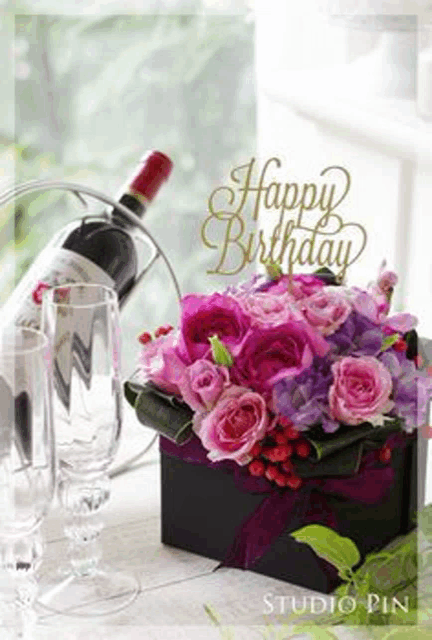 a birthday card with a bottle of wine and a bouquet of pink flowers .